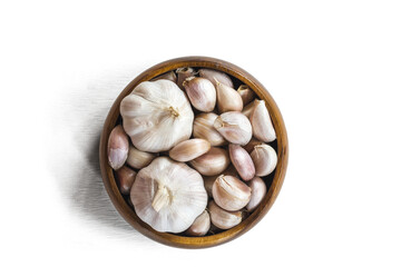 Garlics in wooden bolw  on white wooden planks background.  have path