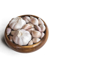 Garlics in wooden bolw  on white wooden planks background. have path