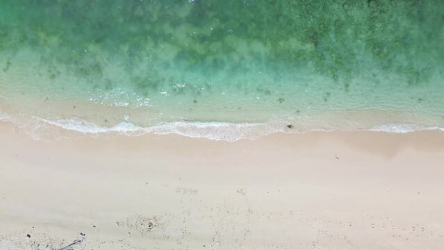 aerial video of calm waves on the beach where the water is very clear
