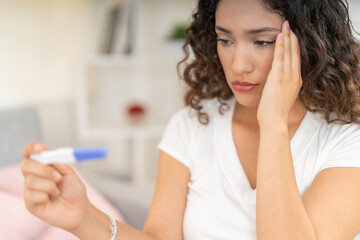 Desolated woman looking at the results of a pregnancy test