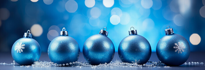 Christmas background with blue baubles on blue bokeh background. banner.