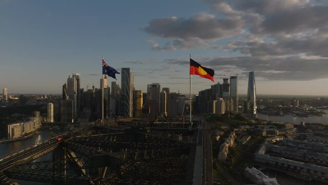 Australian and Aboriginal Flag on Top of Sydney Harbor Bridge, Golden Hour Sunset, With Sydney City Skyline in Background, Aerial
