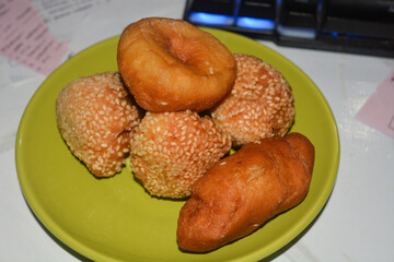 Donuts and dumplings on a small plate on a white background.