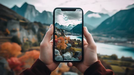 Printed kitchen splashbacks Deep brown Hand of a man holding mobile phone with camera on and natural landscape in background.