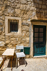 Fototapeta na wymiar table and chair at entrance to the old house, street view of the old town Dubrovnik, Croatia, medieval European architecture, narrow streets in historic city