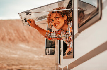 Happy tourist enjoy parking destination opening the window of a modern camper van and looking...