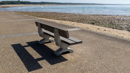 empty bench solo on seacoast beach front of ocean - Powered by Adobe