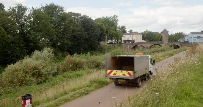 Wide shot of Monnow Bridge next to Monnow river with County council vehicle driving up cycle path