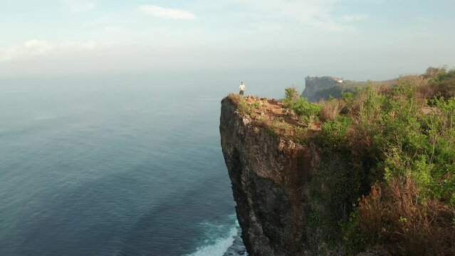 Travel people enjoy breathtaking view at Karang Boma Cliff Bali on background ocean waves crashing on the tropical beach Bali Indonesia 4K Aerial view