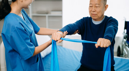 Physiotherapist Helping Patient While Stretching His Leg in bed in clinic .