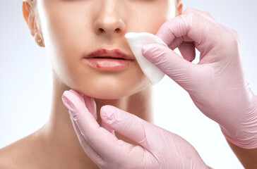 Cosmetologist does injections for lips augmentation and anti wrinkle in the nasolabial folds of a...