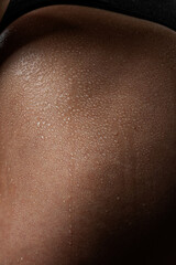 Fototapeta premium Wet skin of a young girl, drops of water are visible on the body close-up