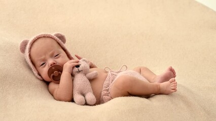 Sleeping newborn cute baby girl or boy during first week of life. 4k slow motion120 fps raw video. Happy family concept. Small baby sleep in bed with small bear toy in hand and nipple
