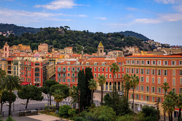 Fototapeta na wymiar Aerial view of Old Town or Vielle Ville buildings, the trees of Promenade du Paillon and Castle Hill or Colline du Chateau at sunset in Nice, France