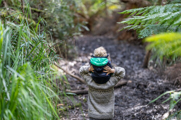 mother giving child a piggyback ride in the forest on an adventure