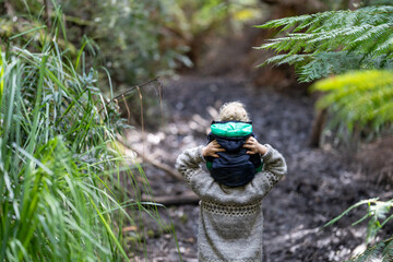 mother giving child a piggyback ride in the forest on an adventure