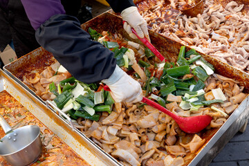 한국의 전통시장 거리에서 판매중인 돼지 껍데기 볶음 요리와 국자로...
