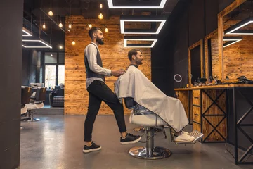 Foto op Canvas Man getting new trendy haircut or hairstyle with professional male barber. © zinkevych
