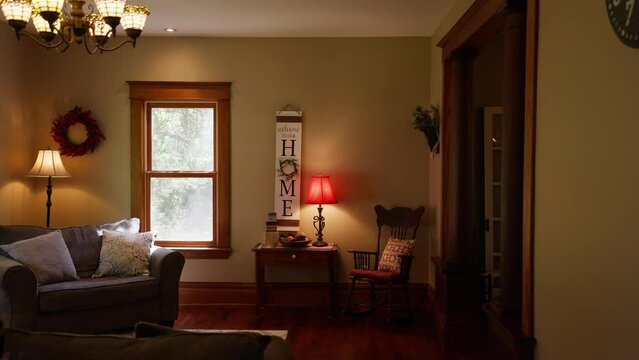 panning shot of a cozy living room in a home with a sign that reads "home" on the wall