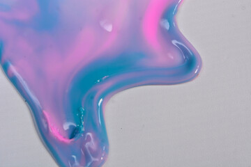 Colorful leaking paint liquid spills from close range
