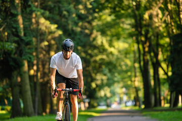 Young man in protective hemlet on a bike in the park