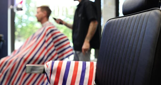 Fashionable hairdresser cuts aman hair with hair clipper in barbershop. Man hairstyle and haircut in salon