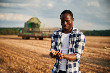 Control of the quality of the product, the wheat. Beautiful African American man is in the agricultural field