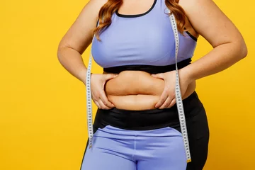 Fotobehang Graffiti collage Cropped young overweight plus size big fat fit woman wear blue top warm up train hold measure tape on waist hold bely skin isolated on plain yellow background studio home gym. Workout sport concept.