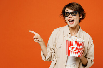 Young surpirsed woman in 3d glasses wear beige shirt casual clothes watch movie film hold bucket of...