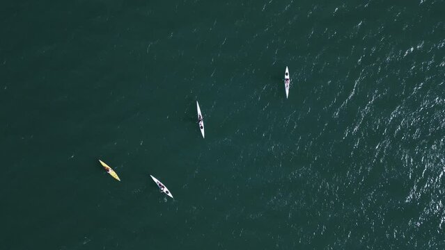 Aerial view of a group of sea kayakers, traveling across the boundless sea, exploring new horizons.