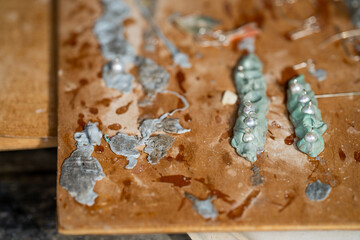 making grass and shell jewellery with tools in a workshop