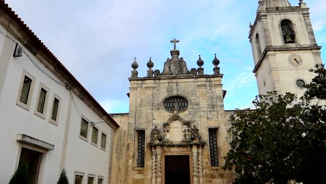 Panoramic view of the exterior of the white Cathedral of Aveiro, Solomonic columns behind a tree. Portugal