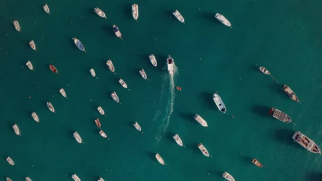 Motor boat aerial top down view around still boats in Calabria Italy