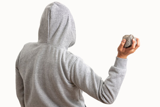 Rear view of a man holding a stone to throw it with white background