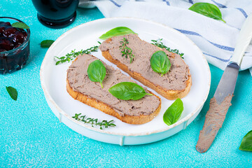 Grilled sandwich with pate with chicken liver and olives on blue background