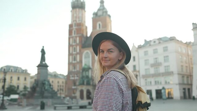 Real view of traveller woman walking on old Market Square in Krakow holding tourist map. Travel and active lifestyle concept. High quality photo. High quality FullHD footage