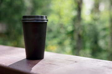 cup of coffee and wonderful forest side Paper cup of coffee wooden bridge against background forest