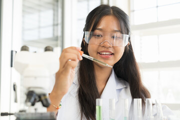 Asian child girl scientists learning science and doing analysis for germs and bacteria with microscope in the laboratory. Science and education, researcher and discovery concept