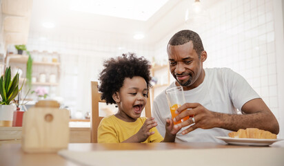 Portrait of happy African american father and son hands drink eat during breakfast time at dining table with copy space. Single dad family love lifestyle, father’s day warm gentle family. - obrazy, fototapety, plakaty