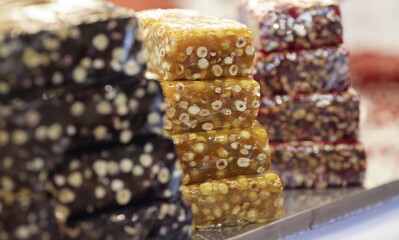 Multi-colored brittle are on counter of store. Sweets from seeds and nuts concept