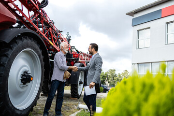 Farmer buying agricultural machines and tractor at local dealership. © littlewolf1989
