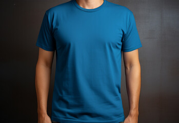 Portrait of handsome young man in blue t-shirt standing outdoors.
