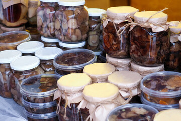 Trade in products in the market. Home preservation, jars with salted and pickled mushrooms
