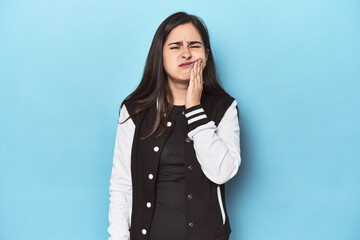 Young Caucasian woman on blue backdrop having a strong teeth pain, molar ache.