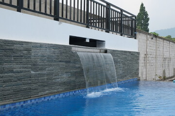 artificial mini waterfall in the swimming pool