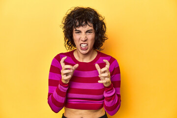 Caucasian curly-haired woman in pink striped-top upset screaming with tense hands.