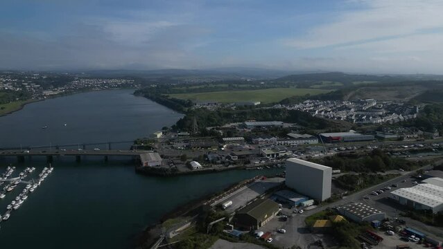 Plymouth, Devon, England: DRONE VIEWS: The River Plym warehouses, factories and moored boats; the Laira Bridge with busy traffic. Plymouth is a thriving port and naval base.