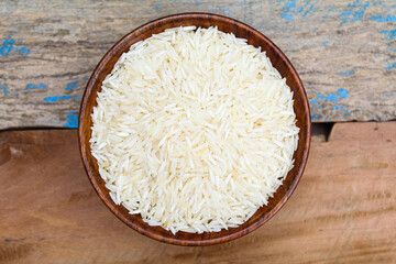 Dry basmati rice in a wooden bowl top view 