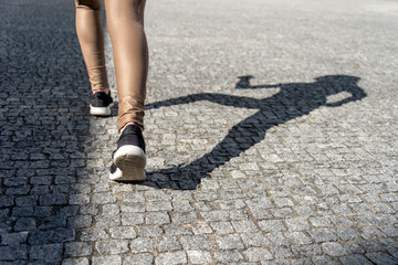 close up of woman shoes running with shadow on cobblestones