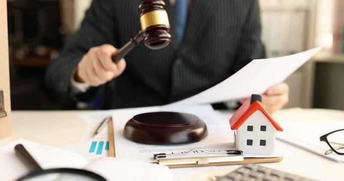 Judge holding documents in his hands and knocking with wooden gavel in courthouse 4k movie. Sale of real estate for auction concept